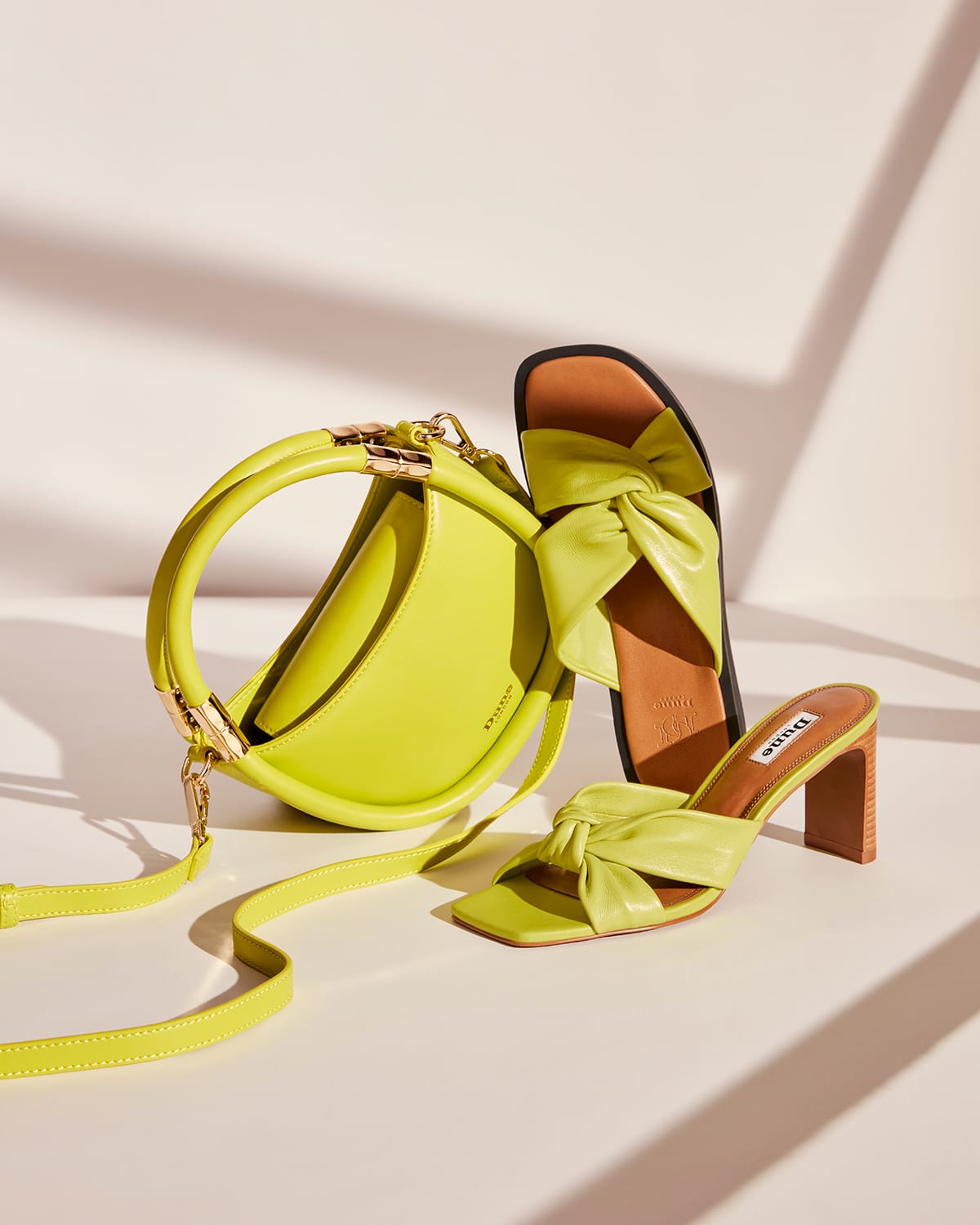 Close up of the Dune London SS23 Daphny bag, Maize mules, and  Lizo sandals in lime green