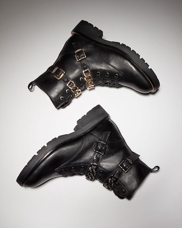 Black women&rsquo;s chunky combat boots with metallic chain front detail.