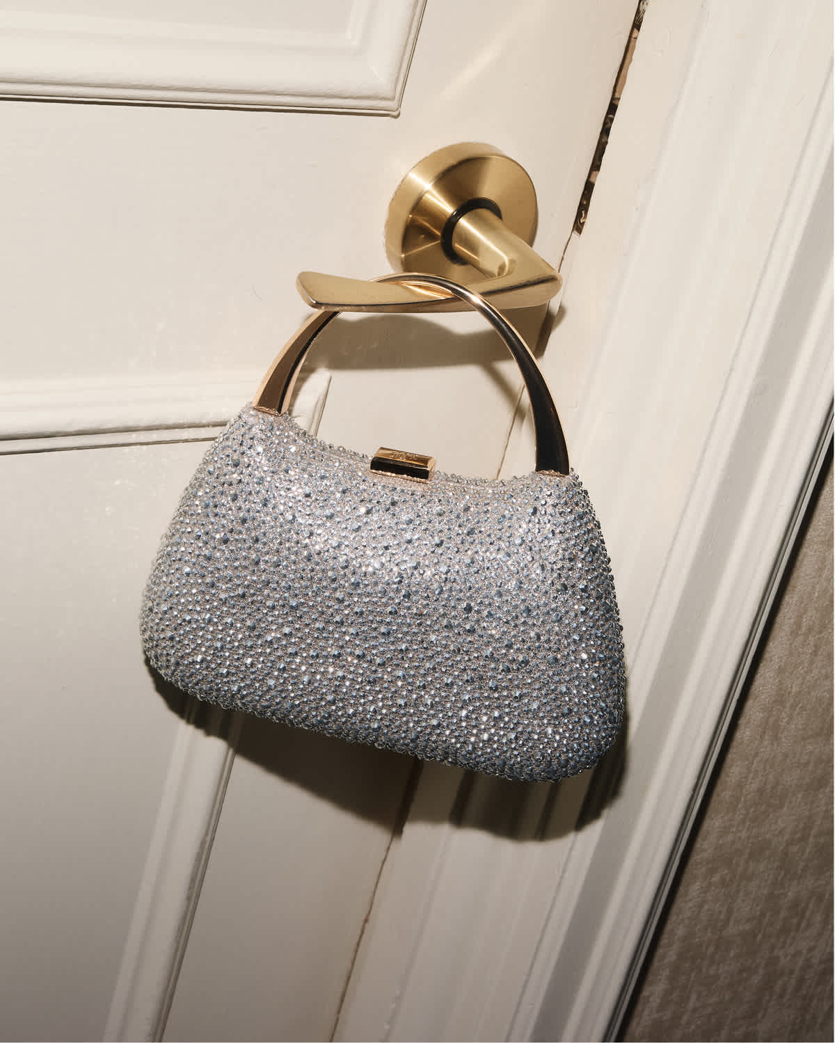Gold handle embellished bag, hung on a door handle