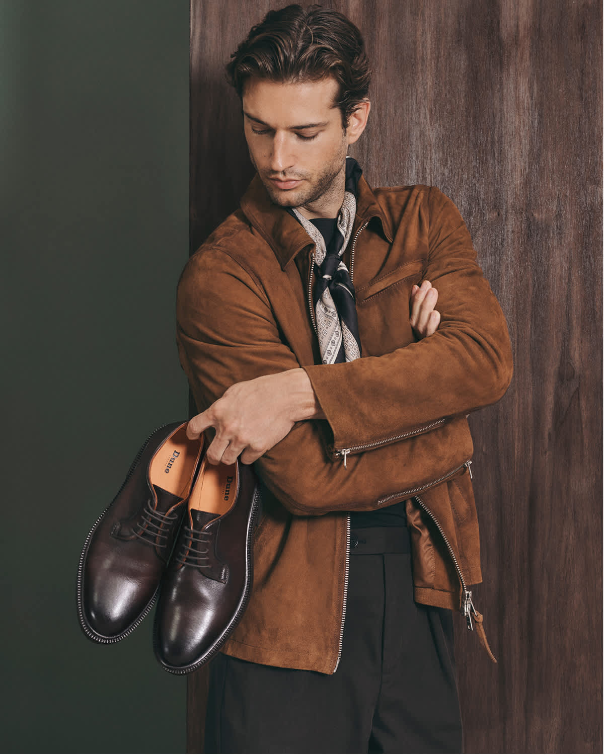 A man holding some formal Dune mens shoes 