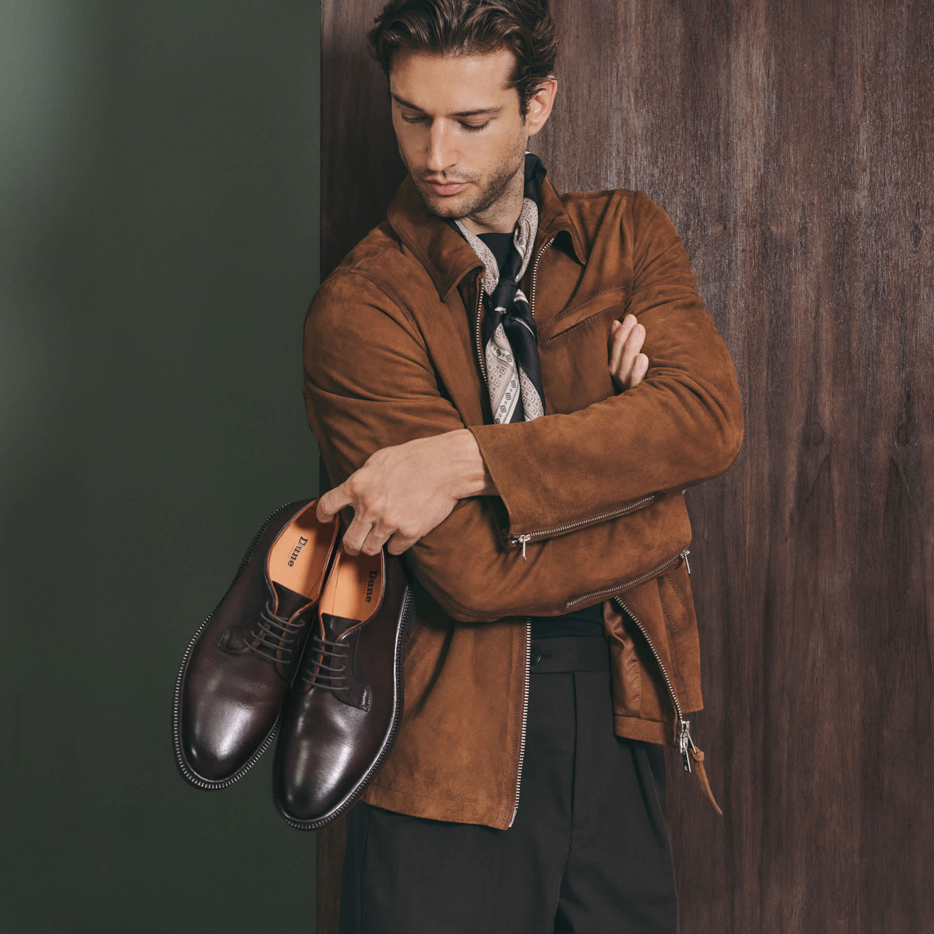 A man holding some formal Dune mens shoes 