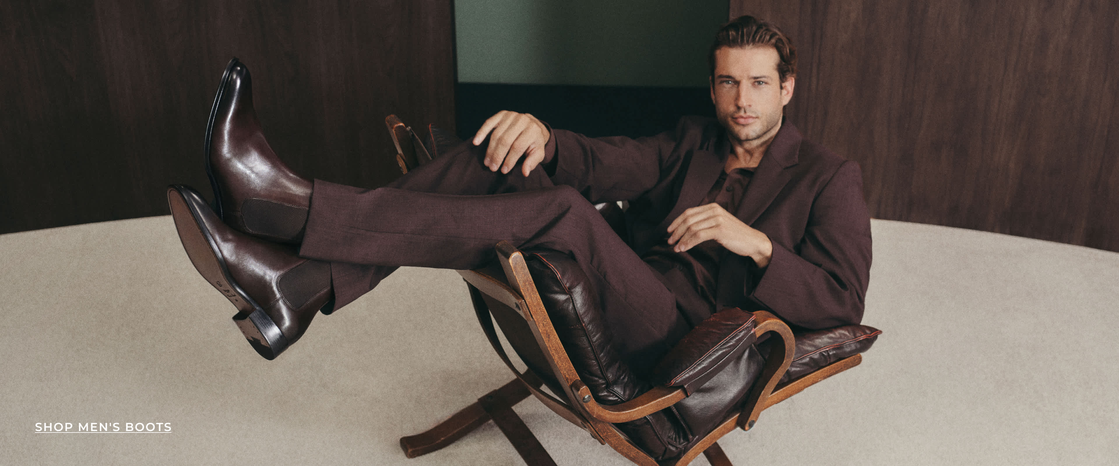 A man wearing formal boots sat on a chair 