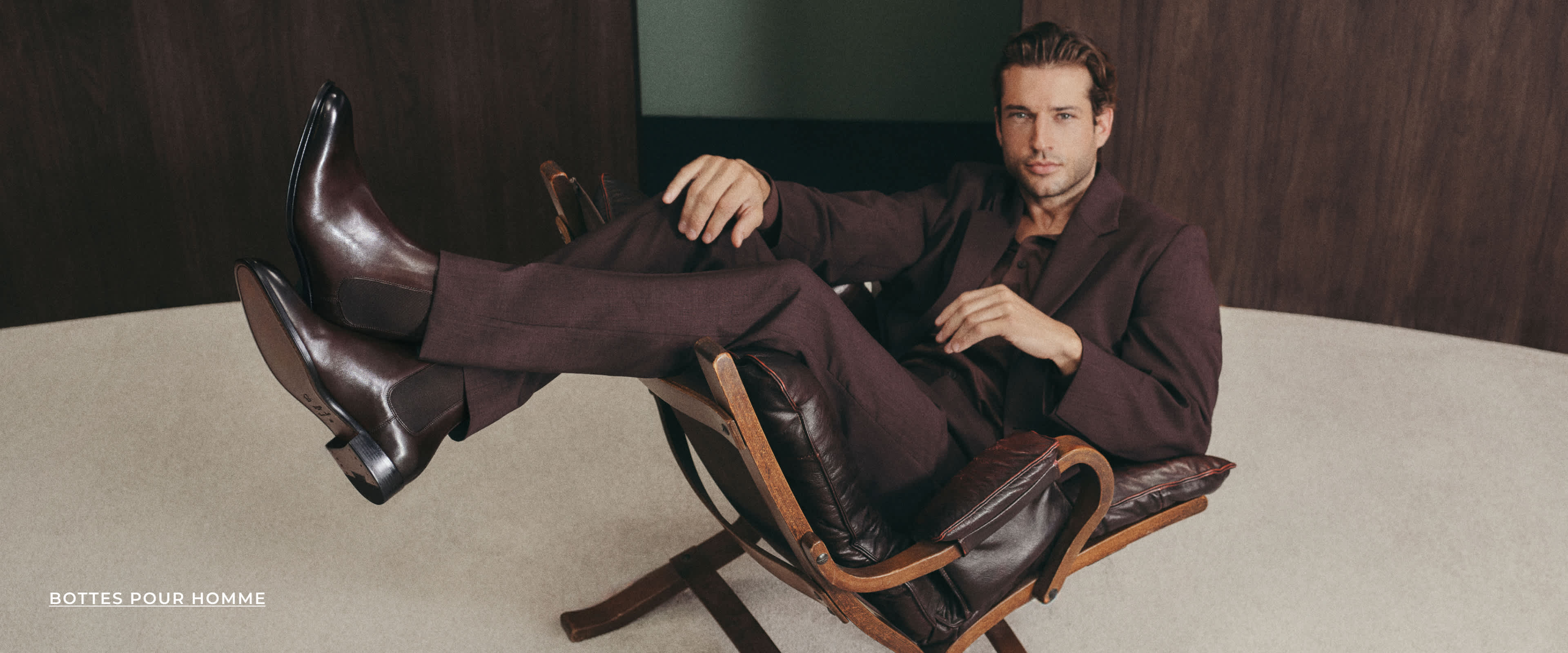 A man wearing formal boots sat on a chair 