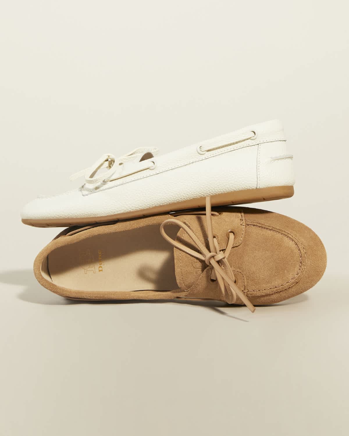Women's suede boat shoes in white and tan with eyelet detail