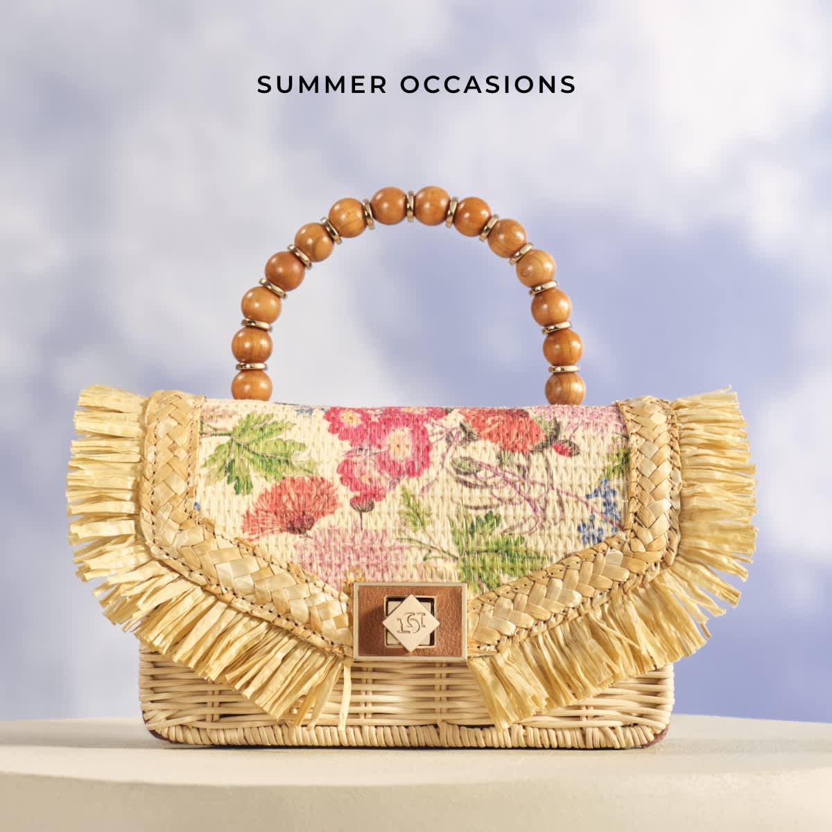 Structured handbag with raffia fringing and wooden beaded top handle
