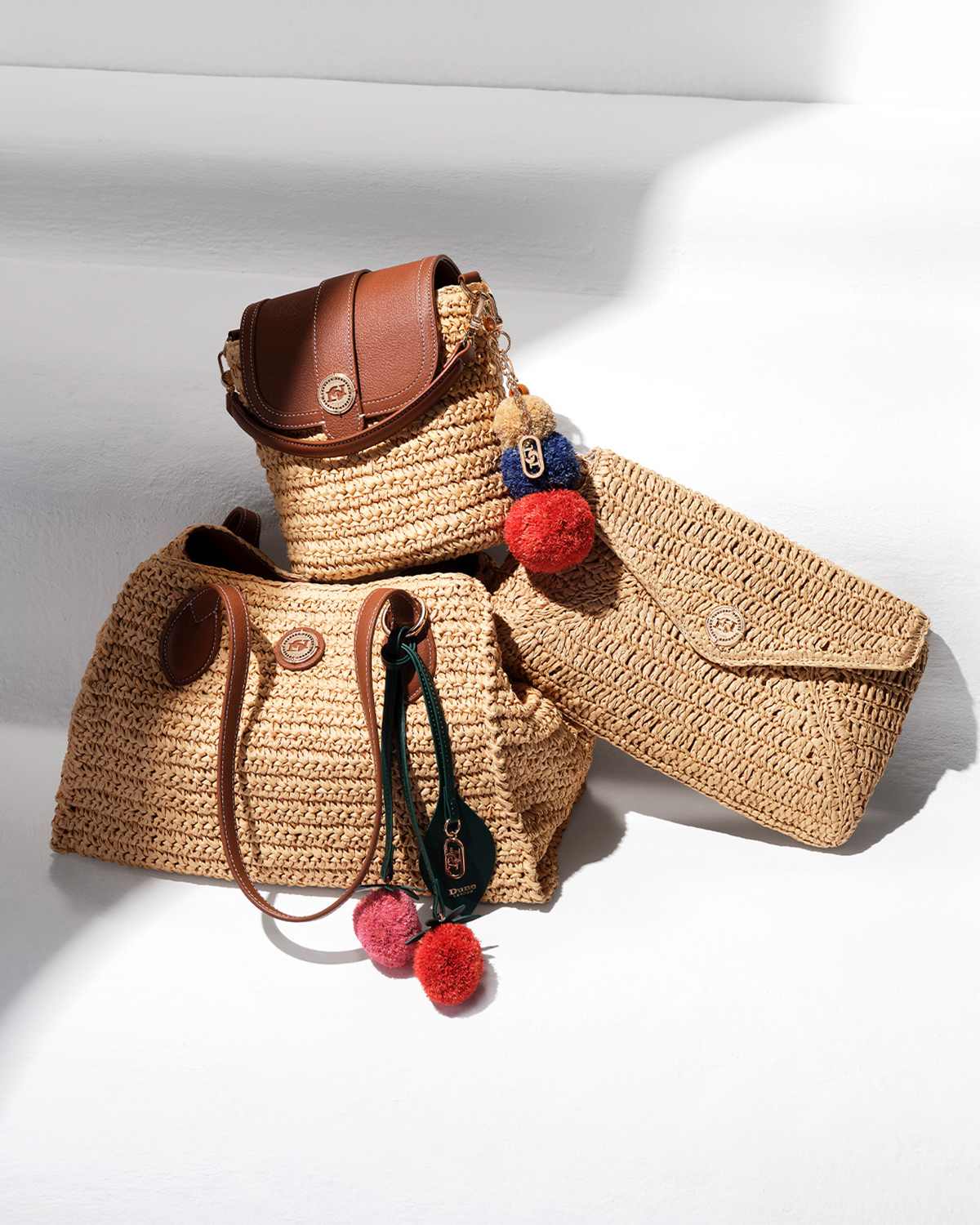 A range of 3 raffia summer bags, clutch bag, shoulder bag and cross body, with pompom trim