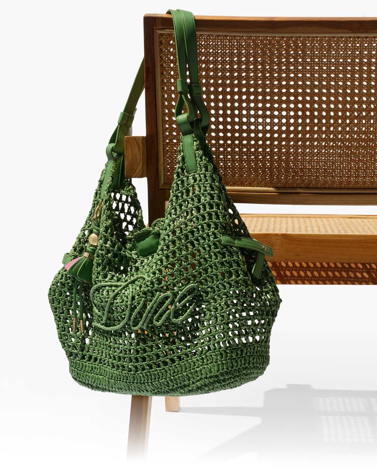 Dune Raffia logo bag on the back of a chair 