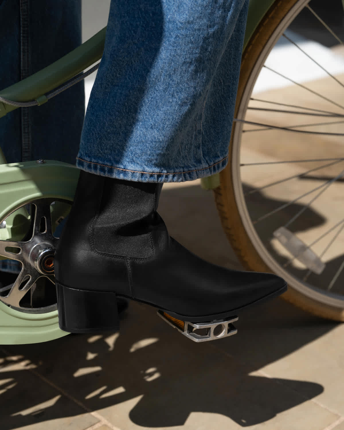 A woman on a bike wearing a black ankle boot