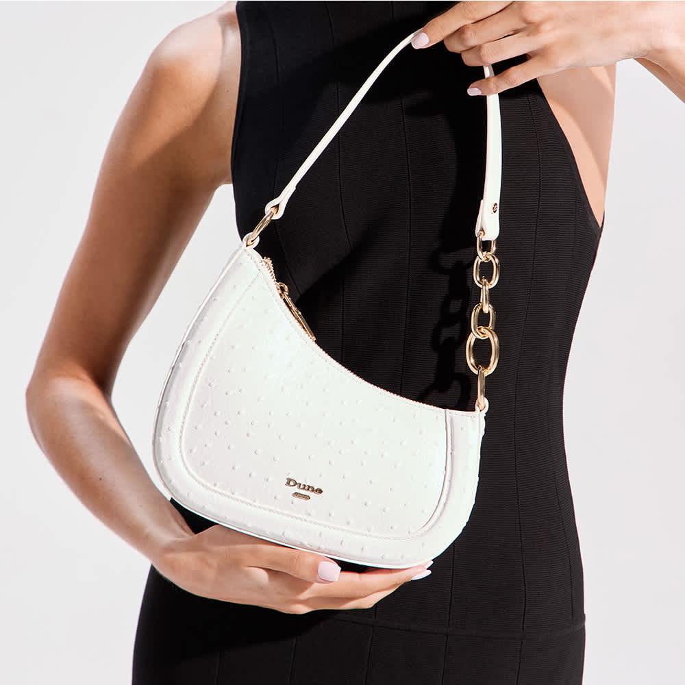 Model holding a white Direction handbag
