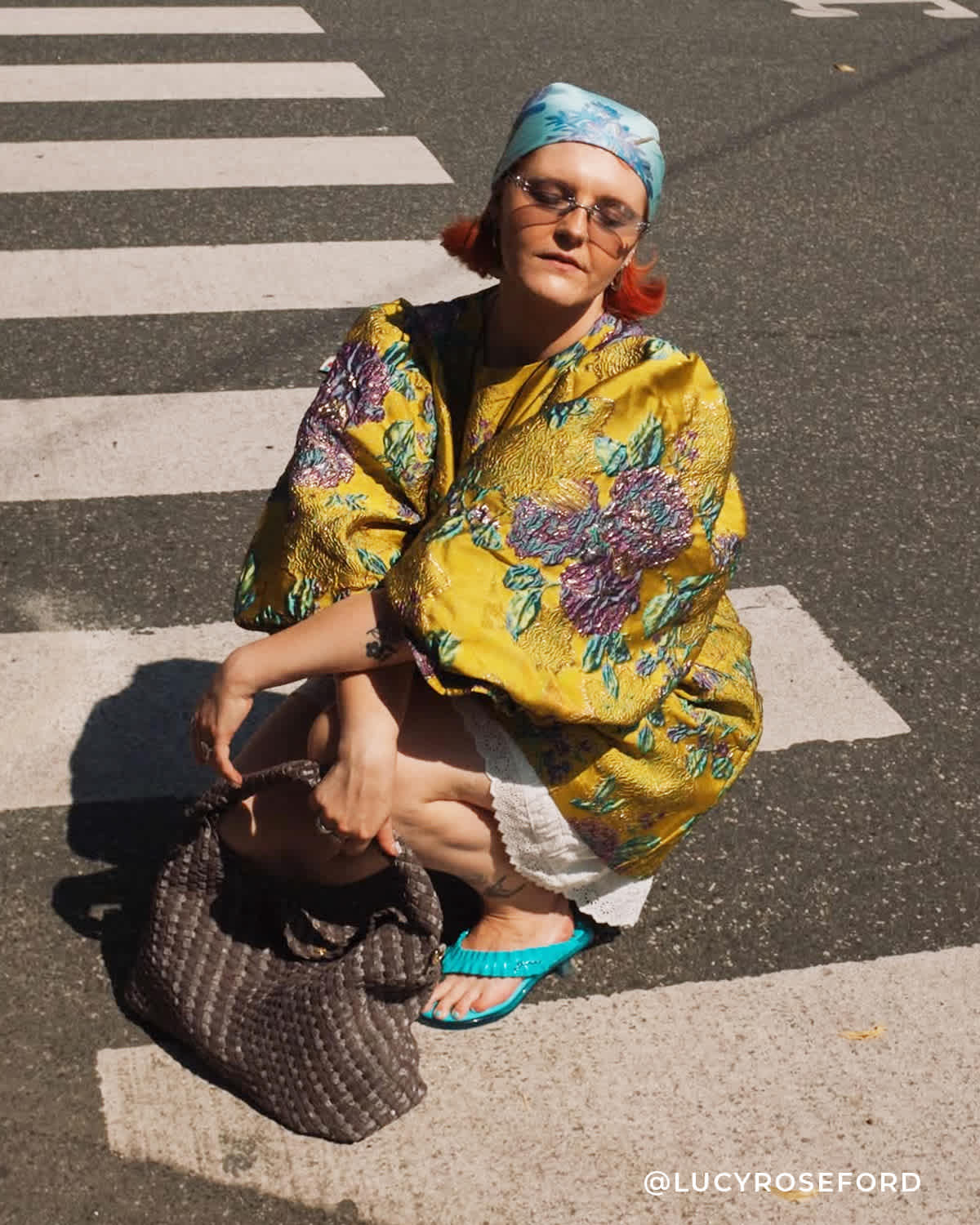 A woman sat down on the street holding a deliberate bag 