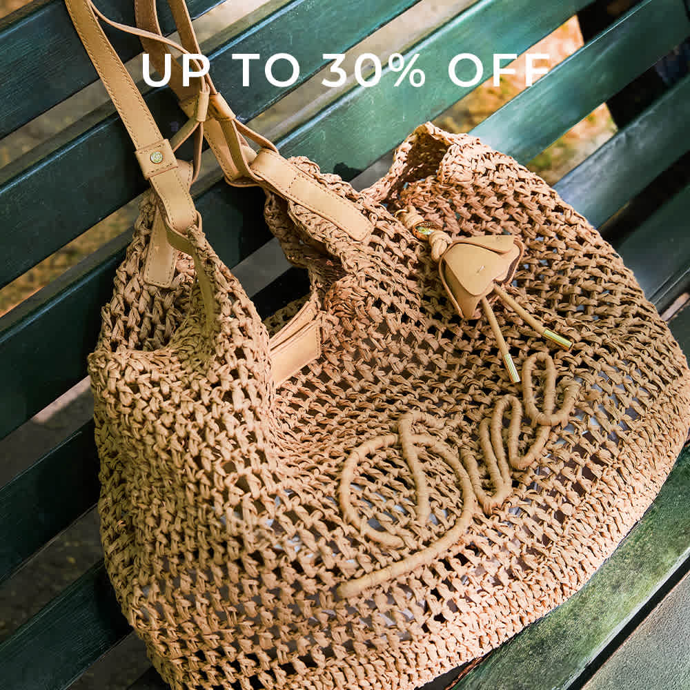A model holding a Dune london handbag on her shoulder 