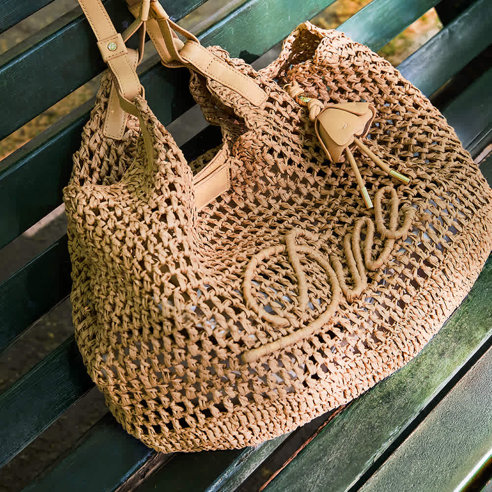 A model holding a Dune london handbag on her shoulder 