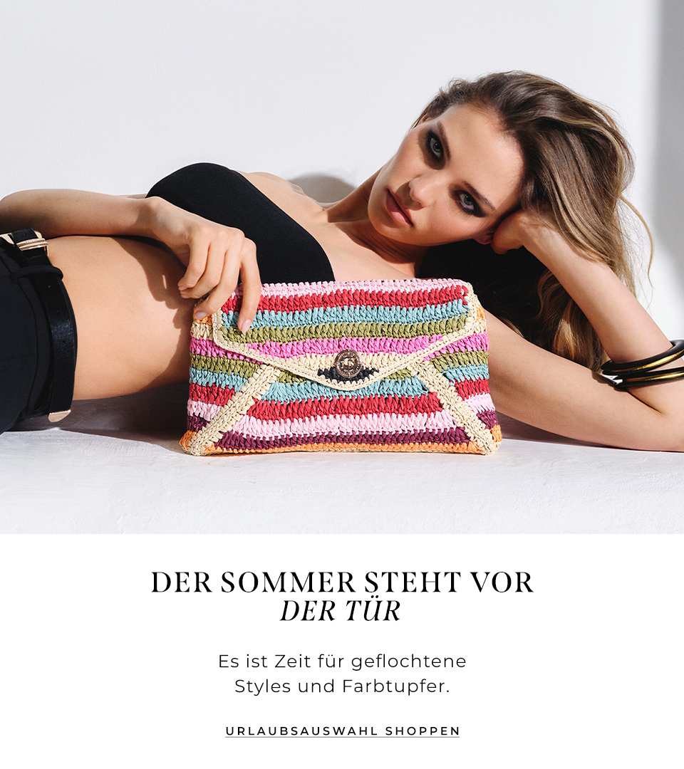 model laying down holding the essentials multicoloured stripe raffia clutch bag